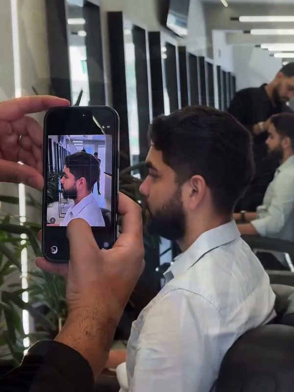 Barbeiro fotografando o cliente para a análise de visagismo